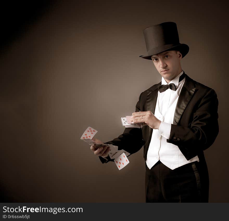 Magician holding playing cards, showing focus, juggles