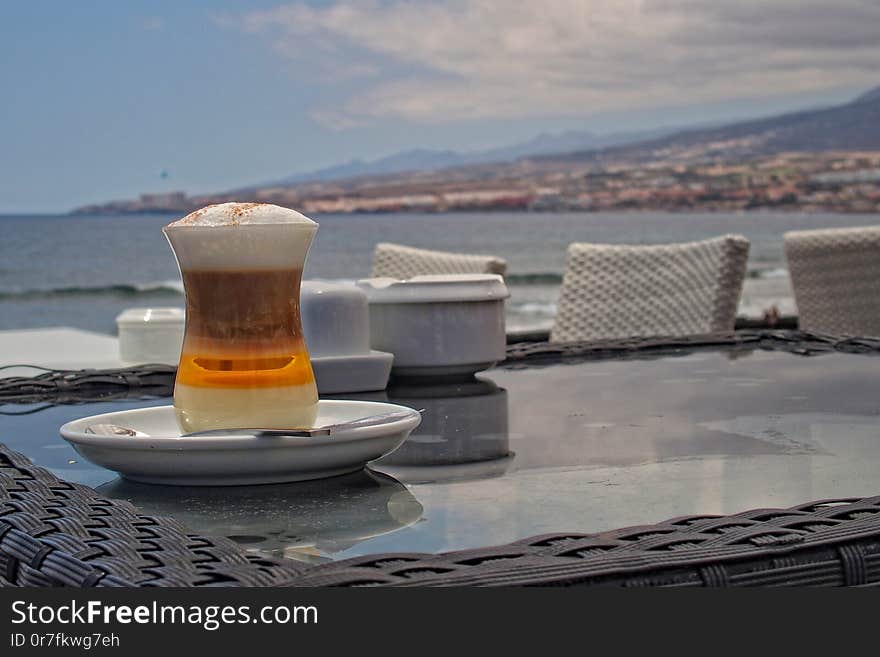 Tasty beautiful colorful sweet coffee on the table in a cafe by the ocean in summer