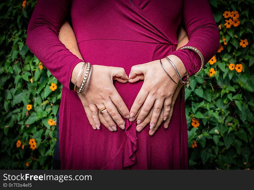 Couple together embracing the pregnancy belly, hands together forming a heart