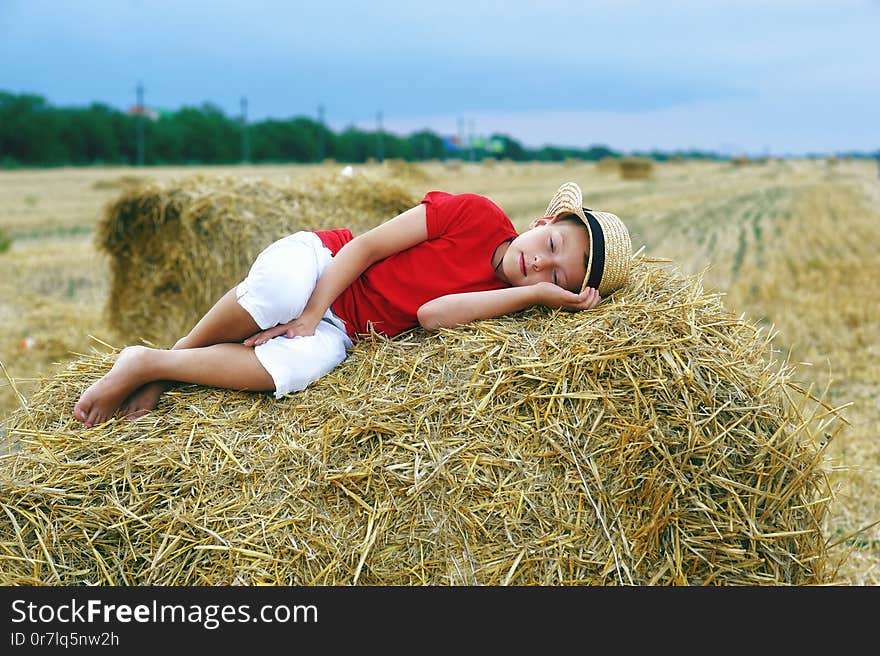 Portrait of a little boy on vacation in the field . The child lying in the manger