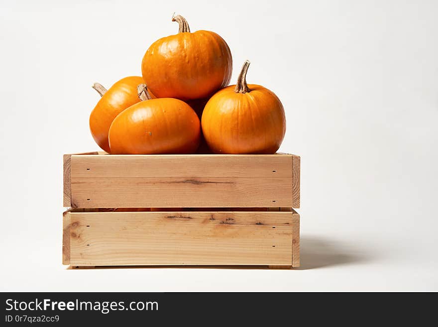 Ripe orange pumpkins in a wooden box