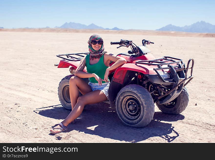 Woman sit on the quad bikes in the desert