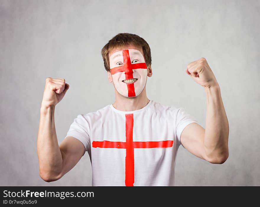 English fan with painted face and t-shirt rejoices. White man. Studio shooting