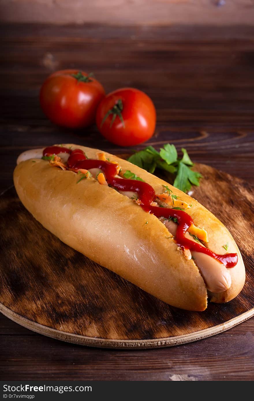 Homemade food Hotdog stuffed with sausage and vegetables in wooden plate on wooden table Close up