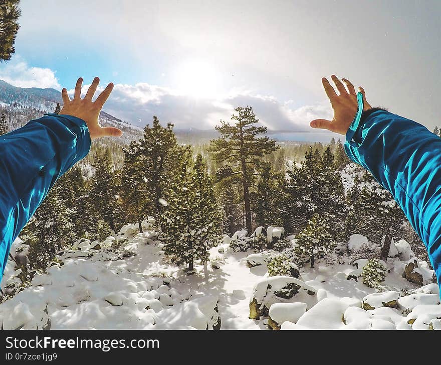 Male hands stretching toward the beautiful snowy forest with South Lake Tahoe in the background