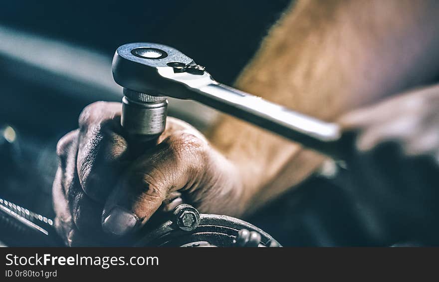 Auto mechanic working on car engine in mechanics garage. Repair service. authentic close-up shot