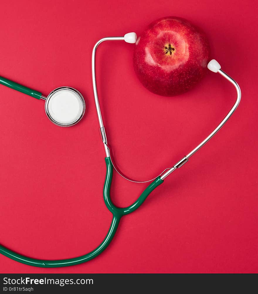 Ripe apple and green medical stethoscope