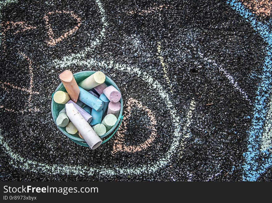 A picture of colorful chalk drawings on a sidewalk in the summer