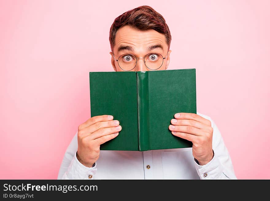 Close up photo portrait of comic cheerful enthusiastic with big staring looking eyes holding paper green book and