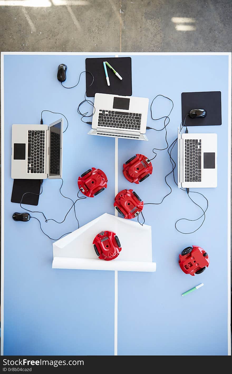 Overhead View Of Laptops And Robotic Vehicles On Table In School Computer Coding Class