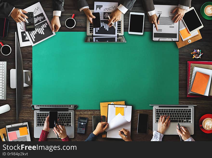 Top view of businessman Group of Multiethnic Busy People meeting with other in modern office with laptop computer, smartphone, tablet, coffee and document on table. Top view of businessman Group of Multiethnic Busy People meeting with other in modern office with laptop computer, smartphone, tablet, coffee and document on table.