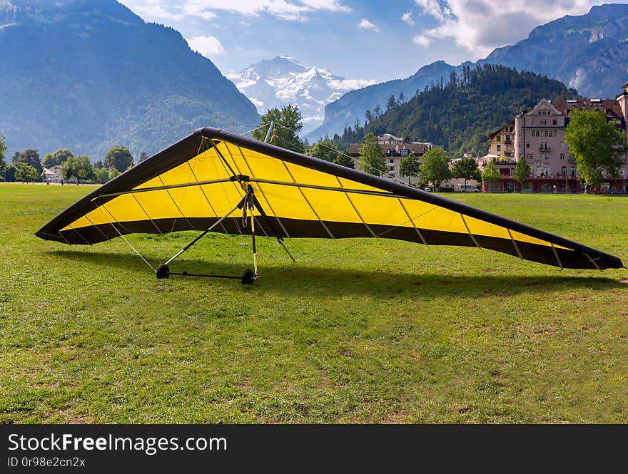 Yellow hang-glider against the background of the Swiss Alps. Interlaken. Switzerland. Yellow hang-glider against the background of the Swiss Alps. Interlaken. Switzerland.