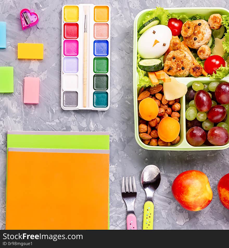 School supplies and lunchbox with food for kids. Colorful stationery layout on multicolor background, copy space