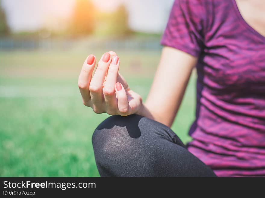 Young woman practicing morning meditation in nature at the park