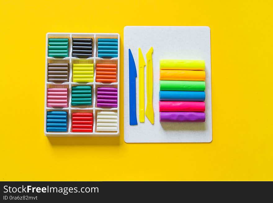 Stationery flat lay.Plasticine rainbow color stack and plastic board. Back to school. yellow background. kid child