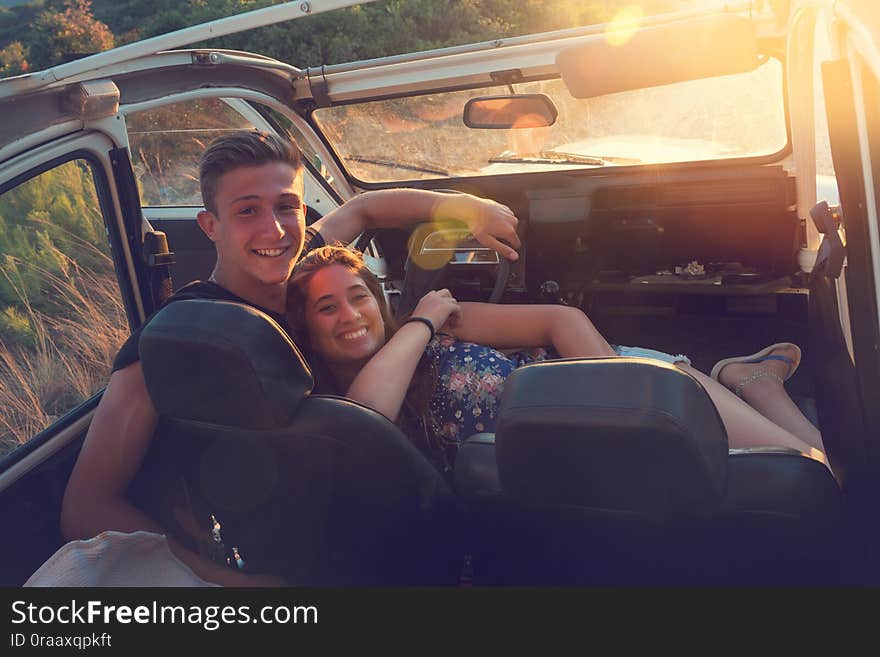 Group of happy people in a car at sunset in summer. Group of happy people in a car at sunset in summer