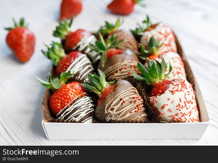 Ripe tasty strawberries covered with white and brown chocolate.