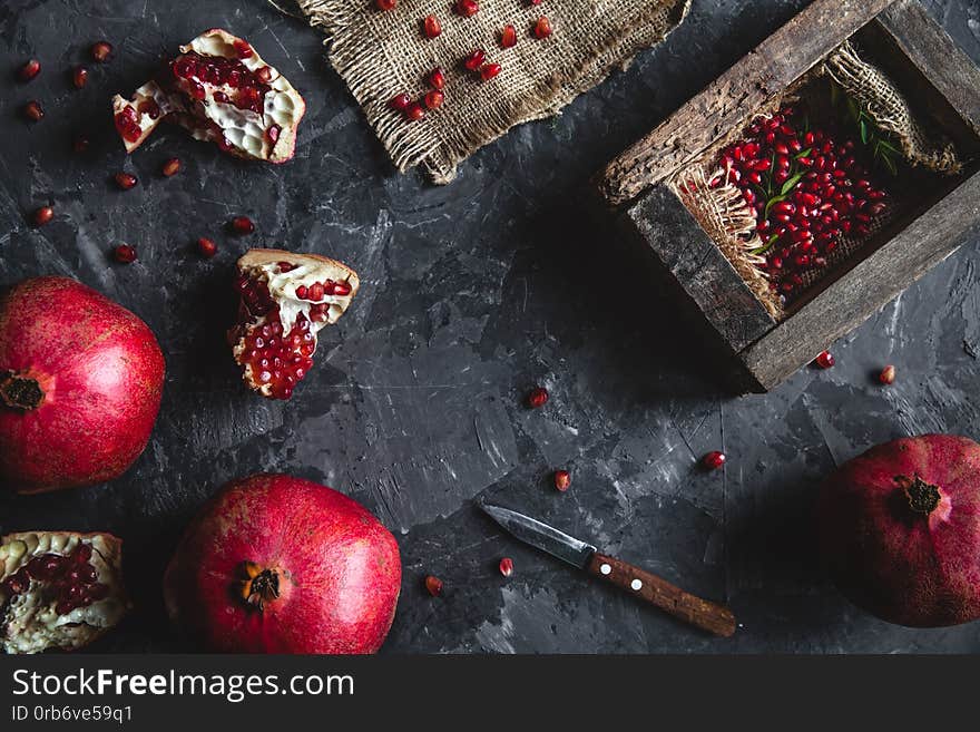 Beautiful composition of pomegranates on a dark background with a towel, healthy food, fruit a