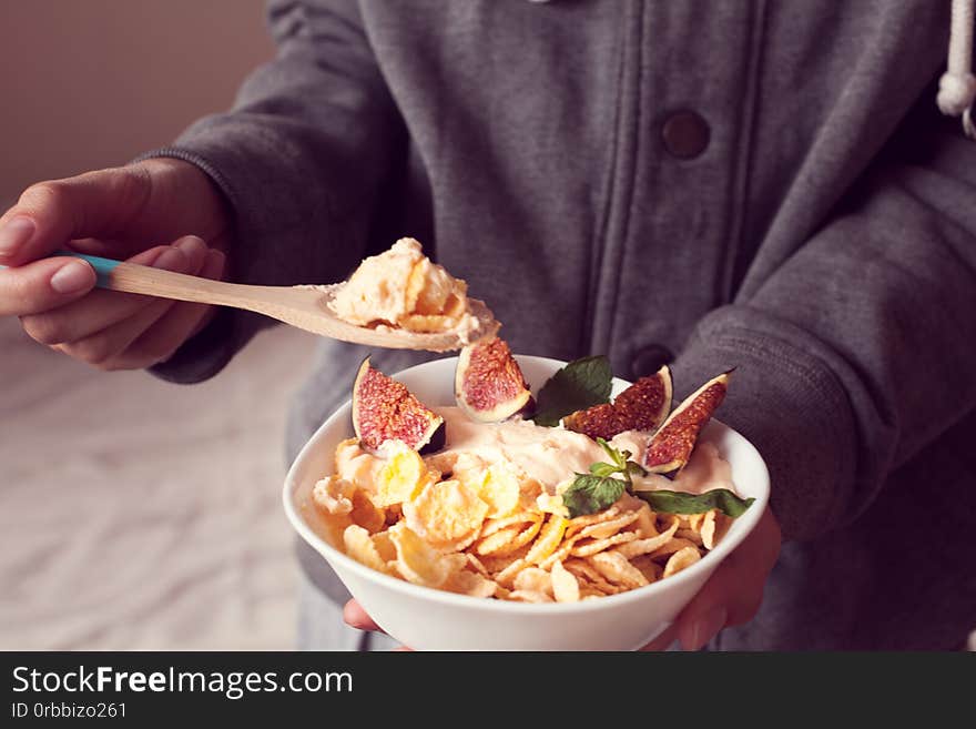 Woman holds a bowl with diet cereal and figs. Woman holds a bowl with diet cereal and figs