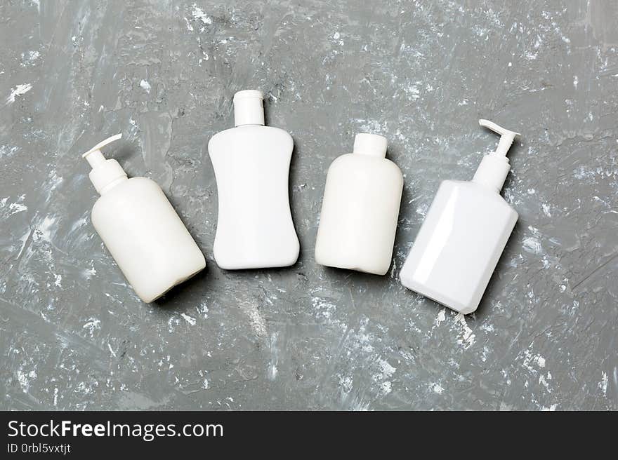 Set of White Cosmetic containers isolated on yellow background, top view with copy space. Group of plastic bodycare bottle containers with empty space for you design.