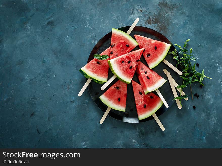 Watermelon slice popsicles on a blue background, top view