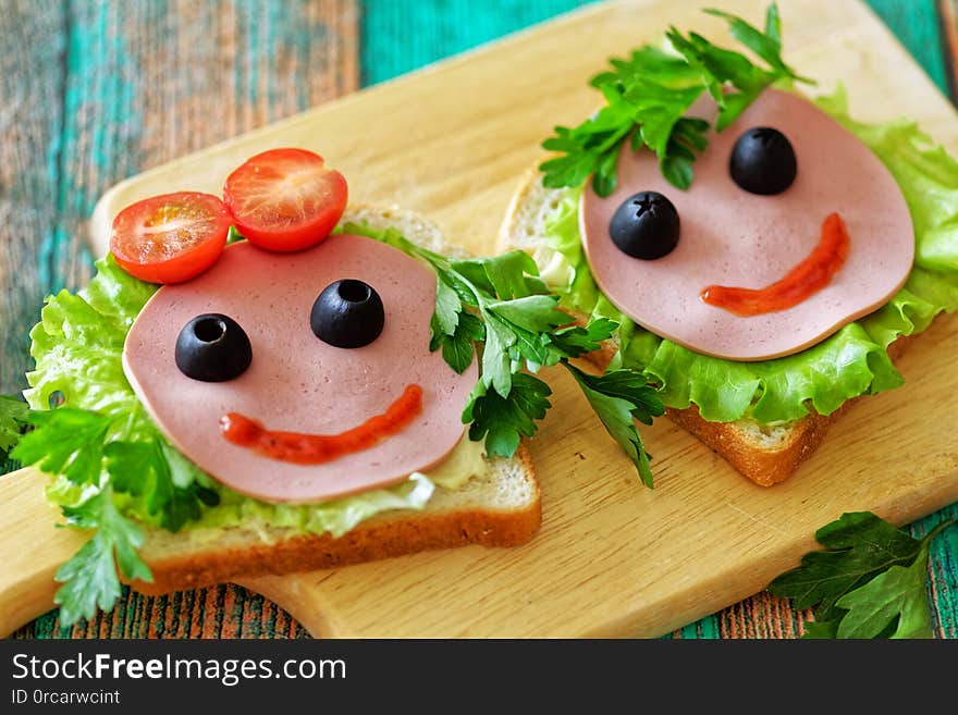 Close up of funny sandwiches the faces of a girl and a boy for a school lunch. Concept back to school.