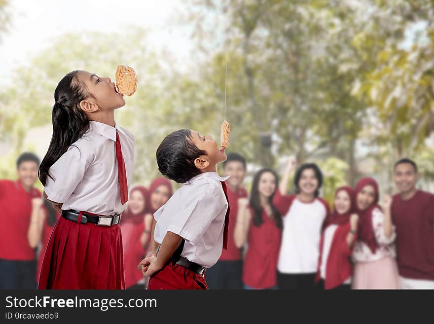 Kids against each other eating indonesian cracker on independence day