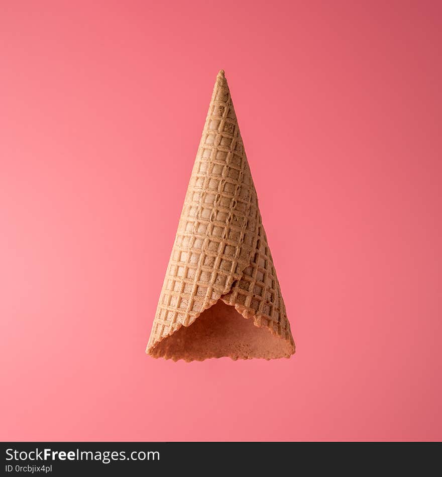 Upside down ice cream cone on bright background. Minimal summer concept.