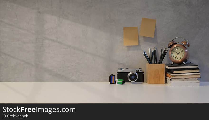 Simple photographer workplace with vintage camera and office supplies with grey wall background
