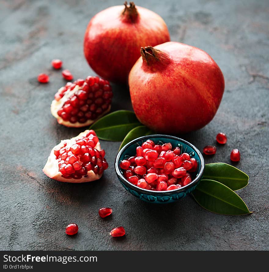 Ripe pomegranate fruits on  black concrete background