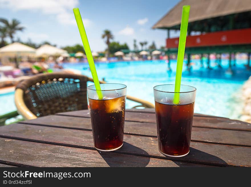 Glasses with cola and ice at the pool on summer holidays