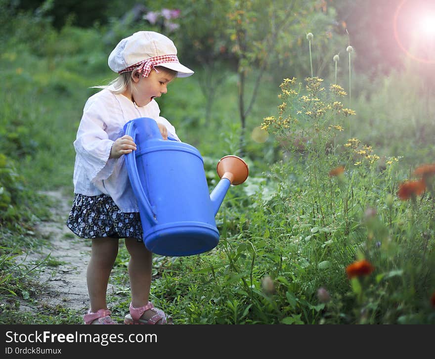 Beautiful white girl watering flowers from watering can. Beautiful white girl watering flowers from watering can