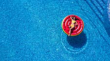 Young Woman Relaxing On Watermelon In Hotel Resort Pool. Top View Of Rich Girl Floating With Fruit Mattress Drinking Cocktail. Royalty Free Stock Photos