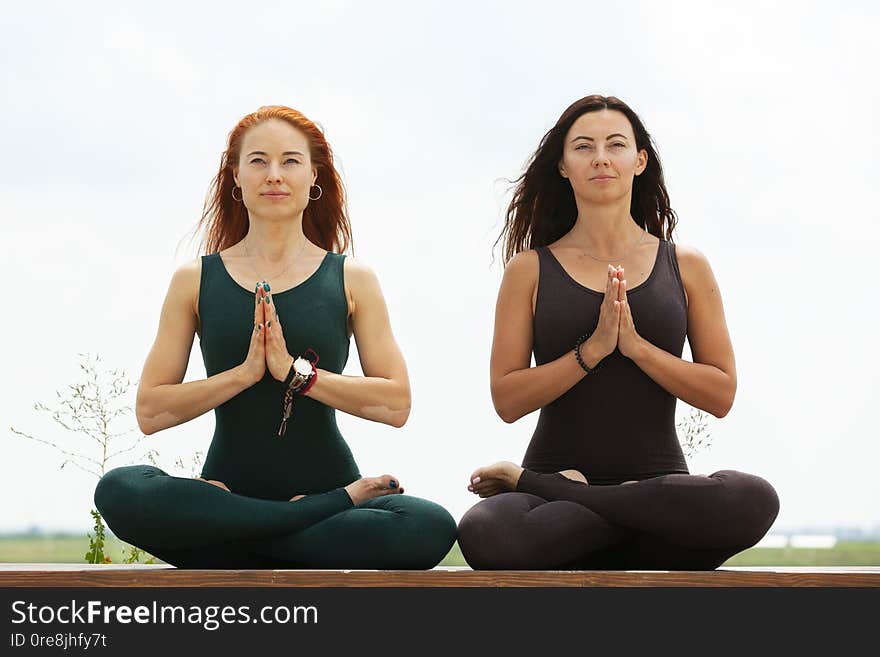 Two women doing yoga outdoors. yoga instructor shows poses. Portrait