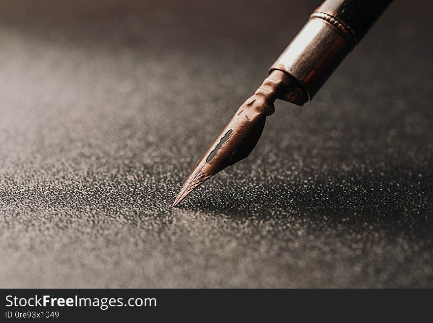Old fountain pen on a black textured background. Old fountain pen on a black textured background