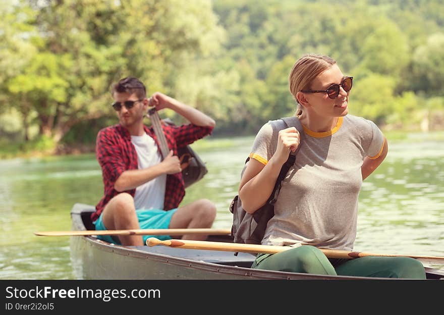 Couple of explorers conoining on wild river