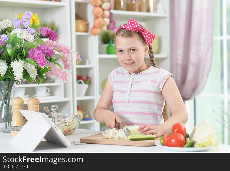 Cute girl preparing delicious fresh salad in kitchen at home. Cute girl preparing delicious fresh salad in kitchen at home