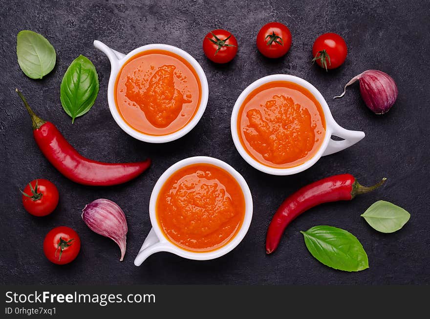 Homemade vegetable red sauce in ceramic bowl on black slate background. Selective focus