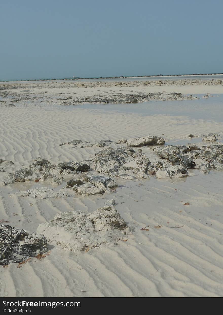 Stones and sand on Fuwairit Beach in Qatar, on a spring day