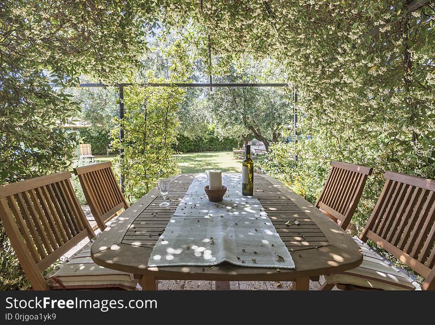 Garden table and chairs surrounded with jasmine flowers. Garden table and chairs surrounded with jasmine flowers