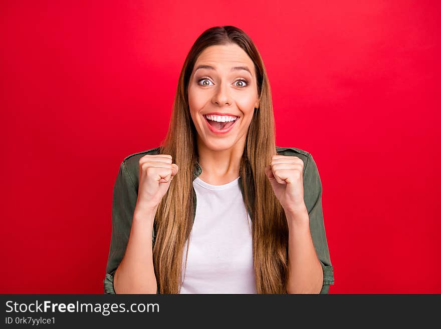 Photo of rejoicing enjoying nice cute woman showing her victory with fists while isolated with red background