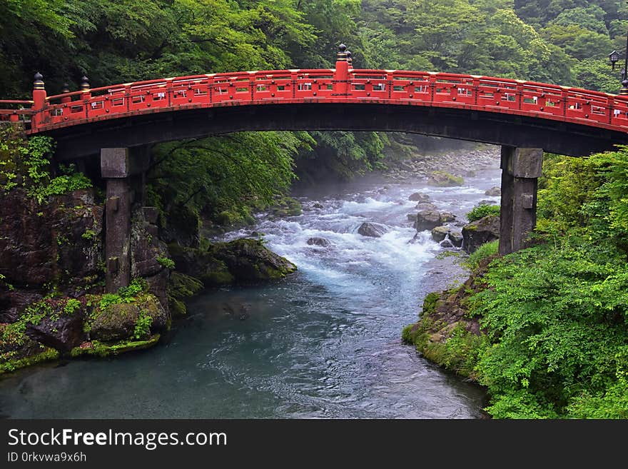 Shinkyo Bridge over the Daiwa River in Nikko outside of Tokyo, Japan in summer with cloud cover.