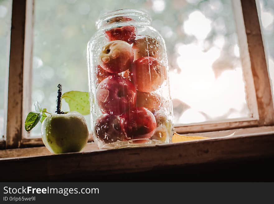 Fresh harvest of ripe and healthy farm apples in a glass jar, in a basket