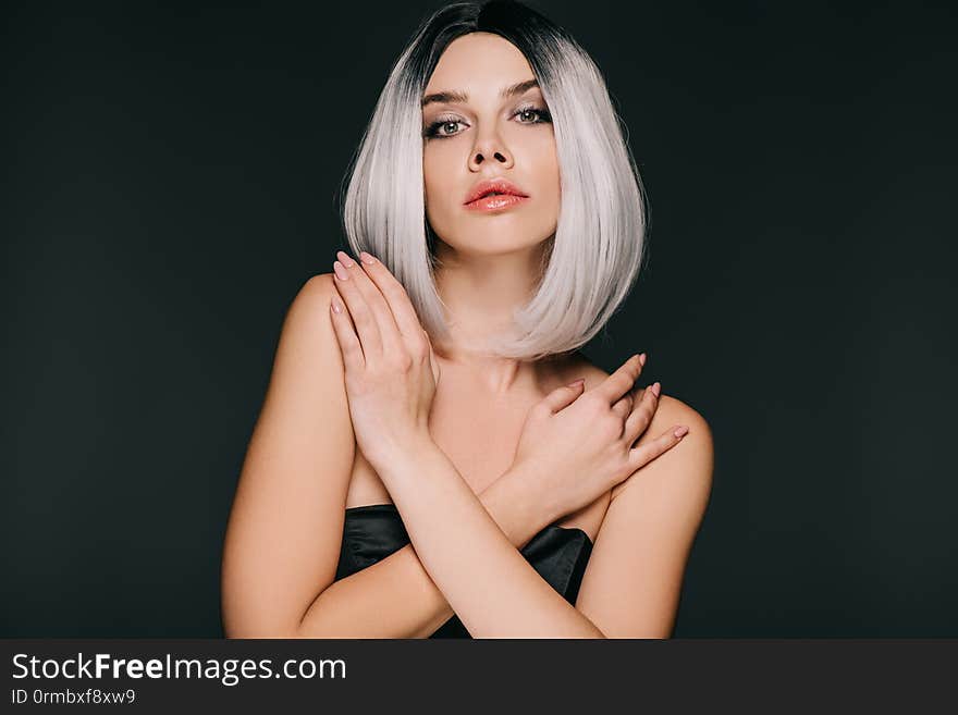 Beautiful glamor girl posing in grey wig, isolated on black