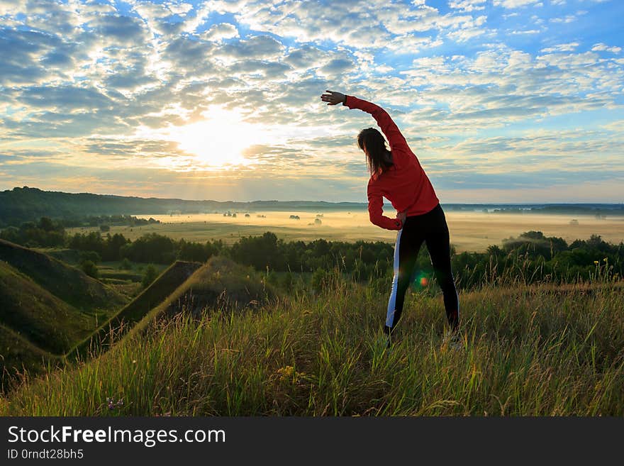 Girl in the nature doing yoga exercise for fitness, at sunrise