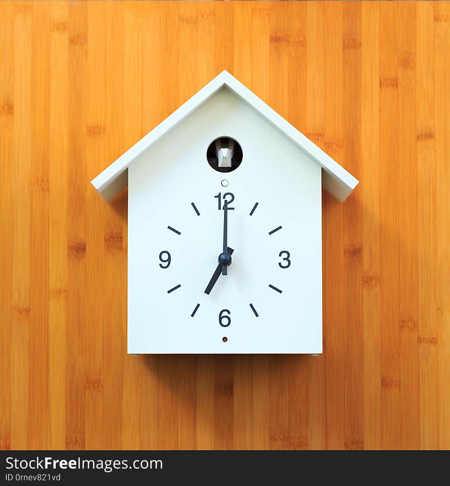 Isolated object, Vintage white wall clock with birdhouse style on wooden background