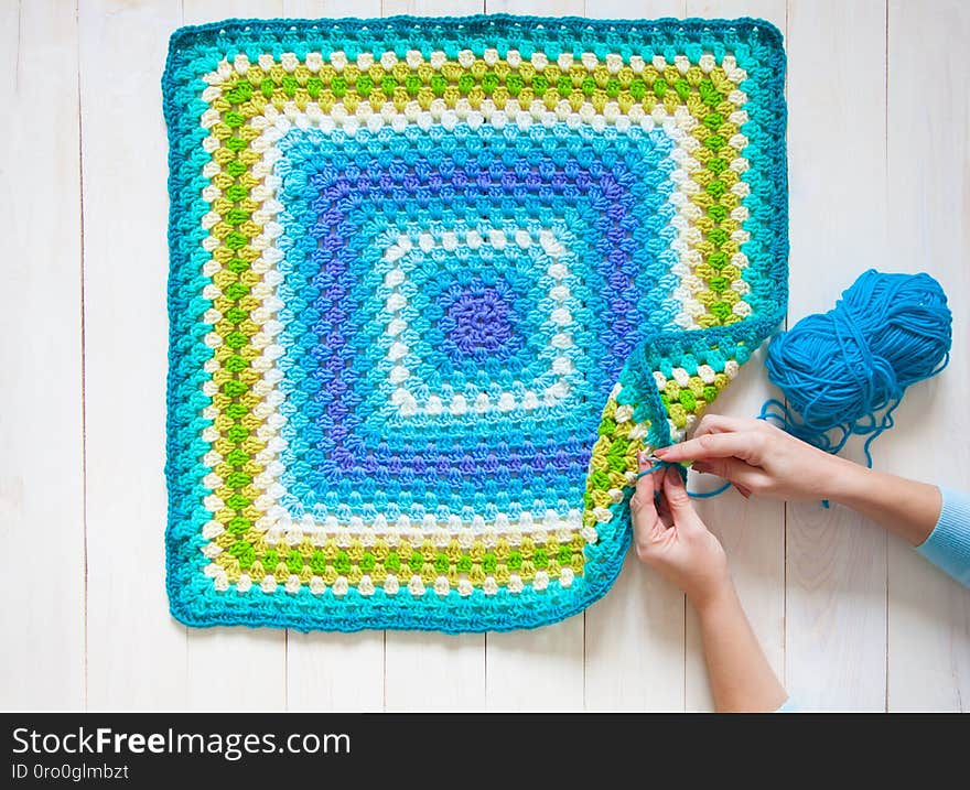 Female hands knitting with color wool, top view