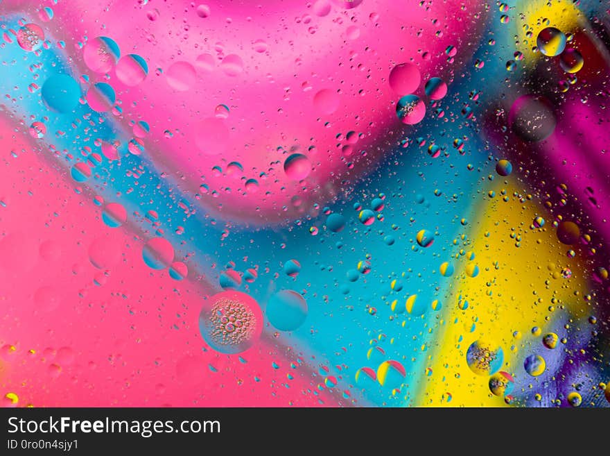 Micro molecular abstract pattern of colored oil bubbles on water.