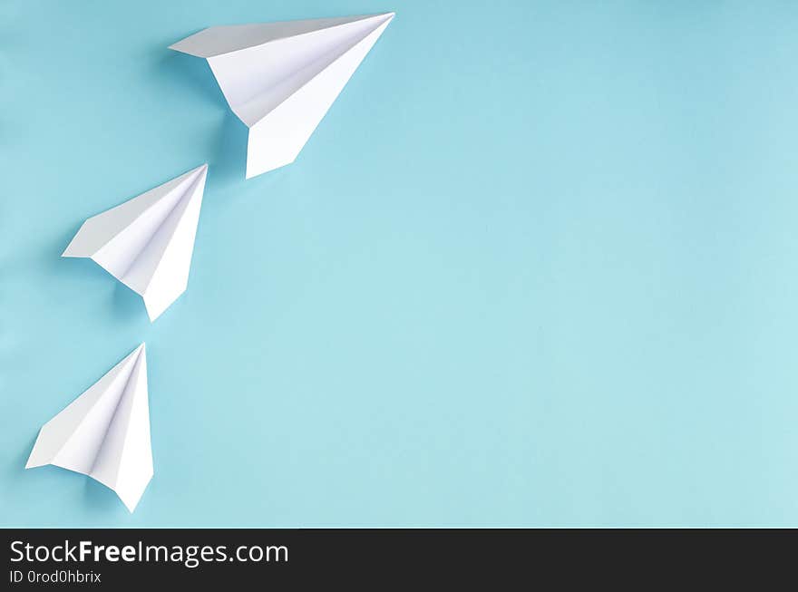 White paper planes on blue background composition