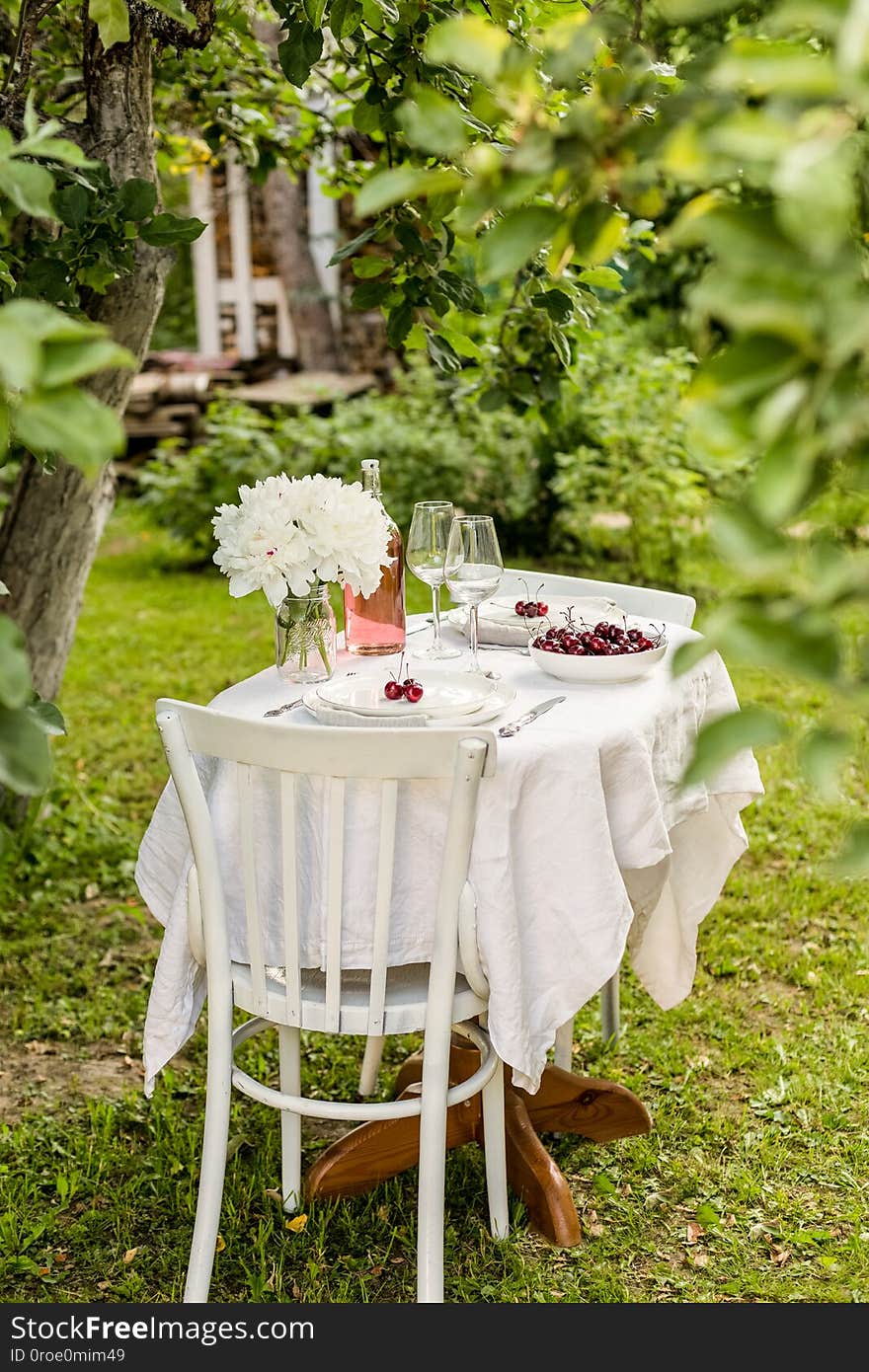 Outside table set with flowers and two serving plates with sweet cherry